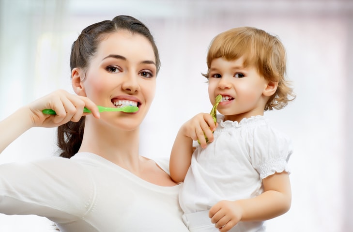 mother and daughter brush their teeth