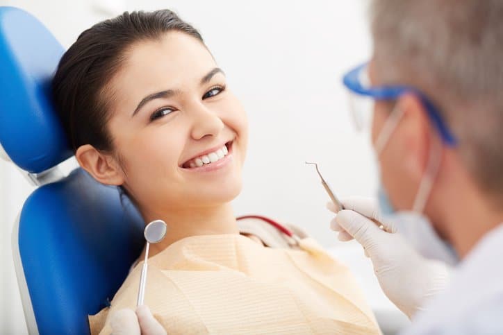 Image of smiling patient looking at camera at the dentist?s
